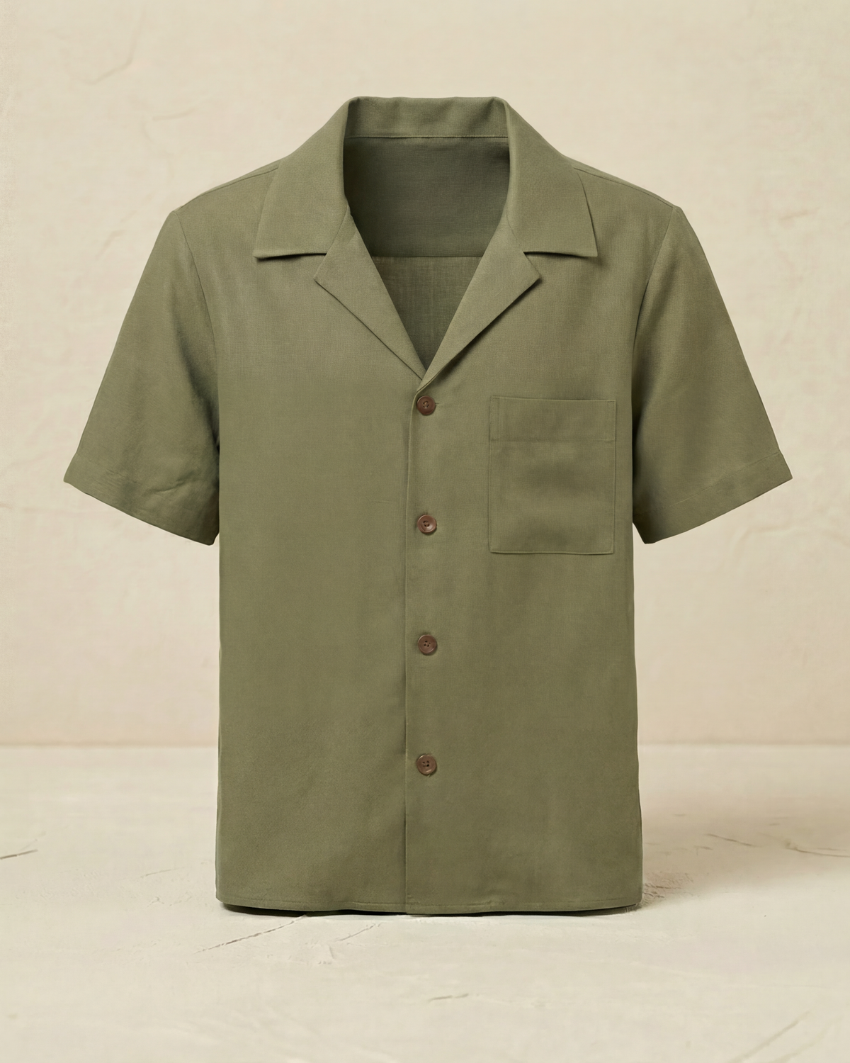 Green short-sleeve shirt with buttons on a beige background