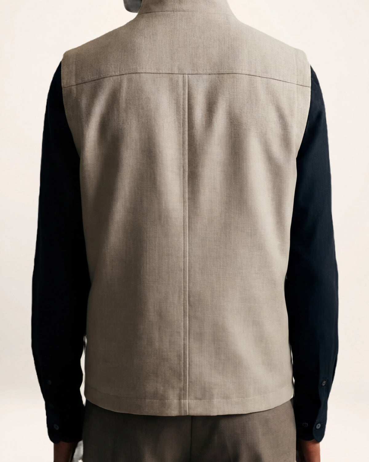 The Ascent Vest — grey-beige zip vest, back view on a model