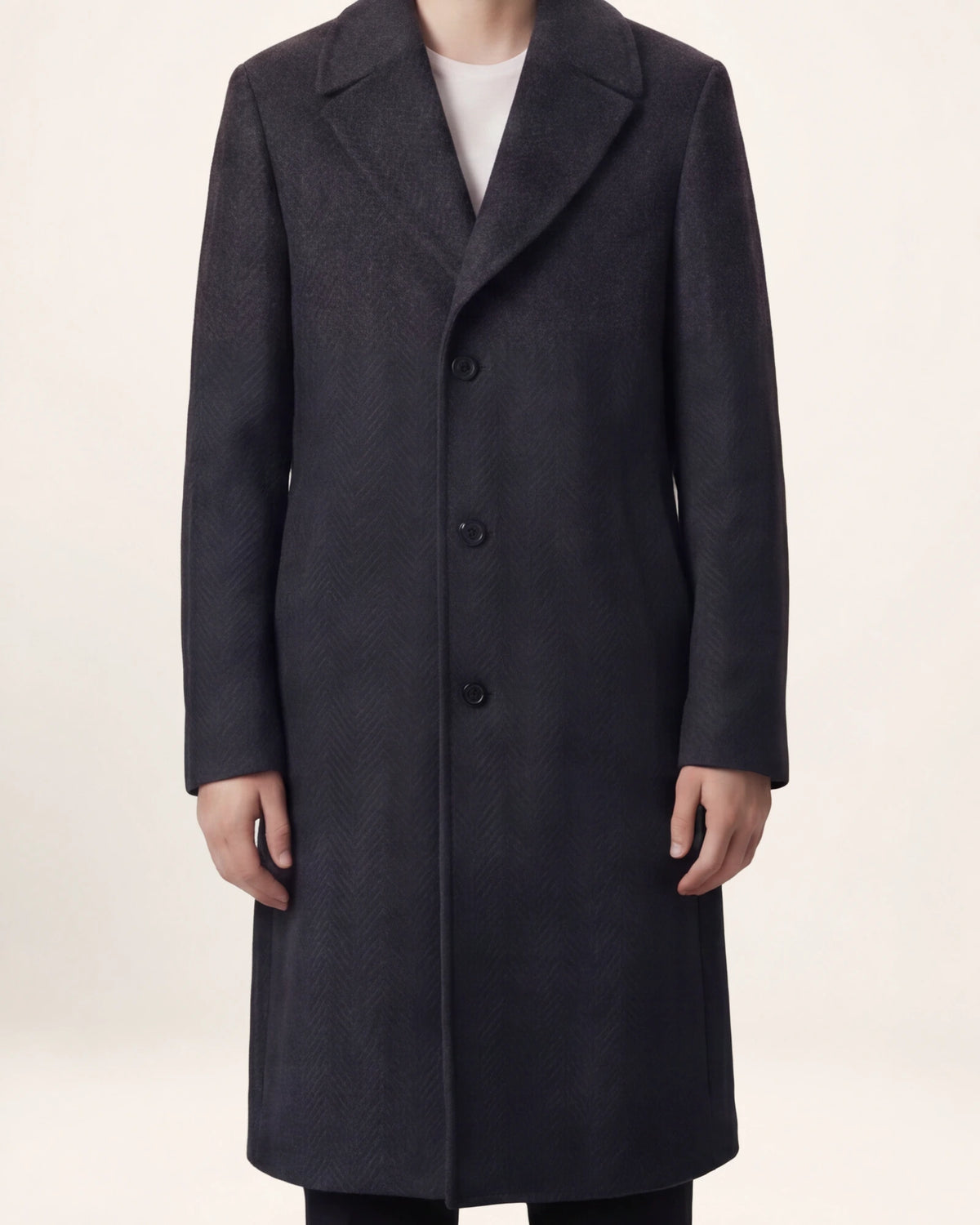 The Sovereign Coat — charcoal coat, front view on a model