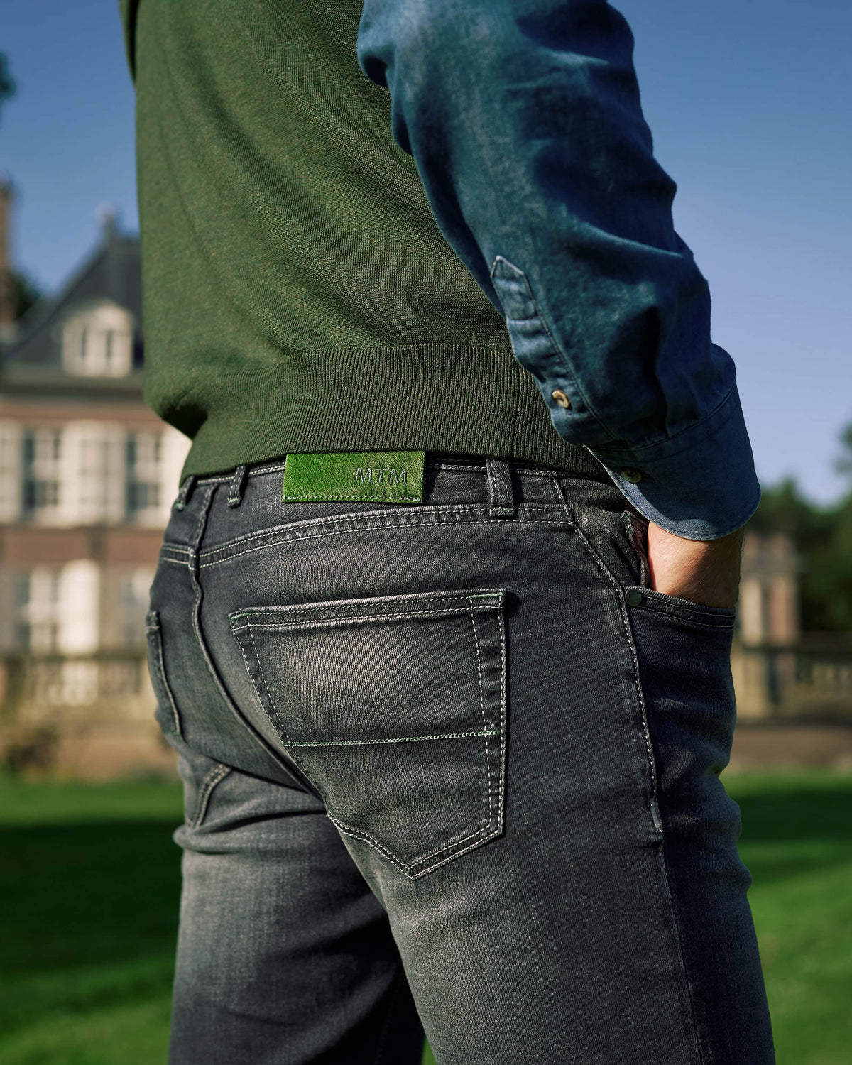 The Stretch Denim — denim, dark jeans worn outdoors, back pocket view