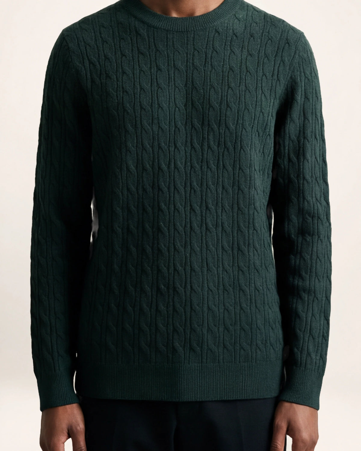 The Depth Knit — deep green cable-knit sweater, front view on a model