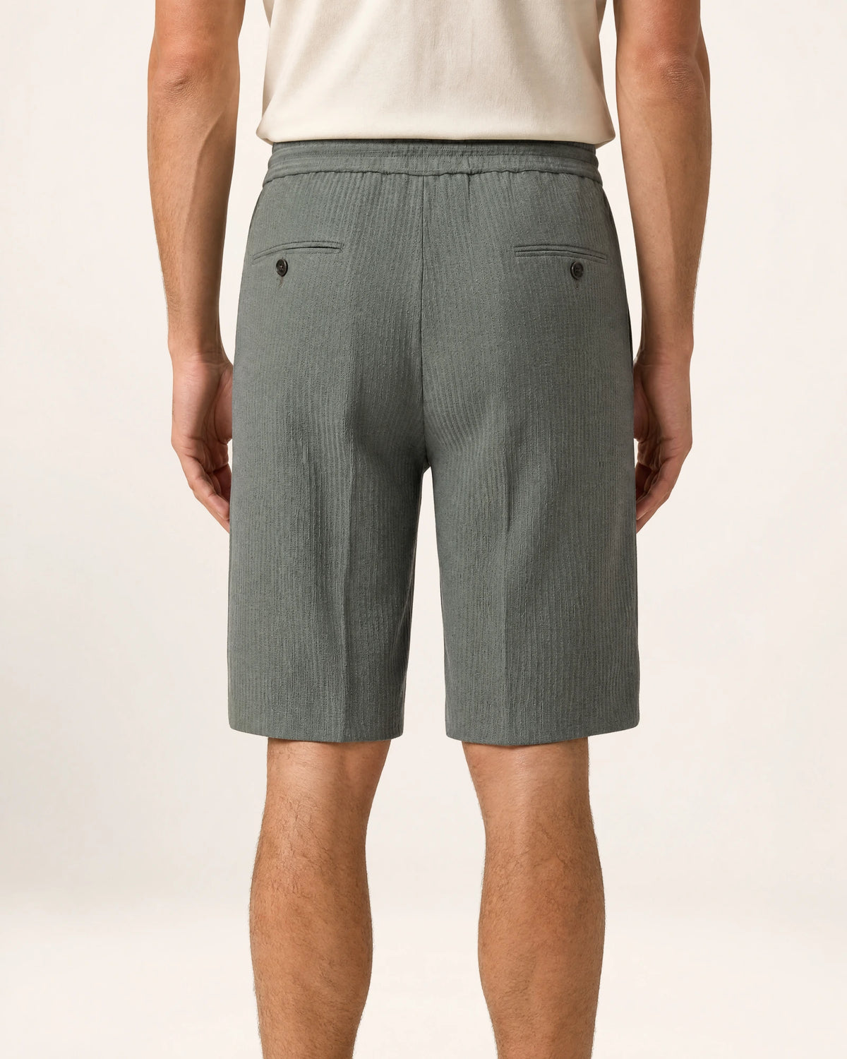 The Dune Short — grey-green shorts, back view on a model
