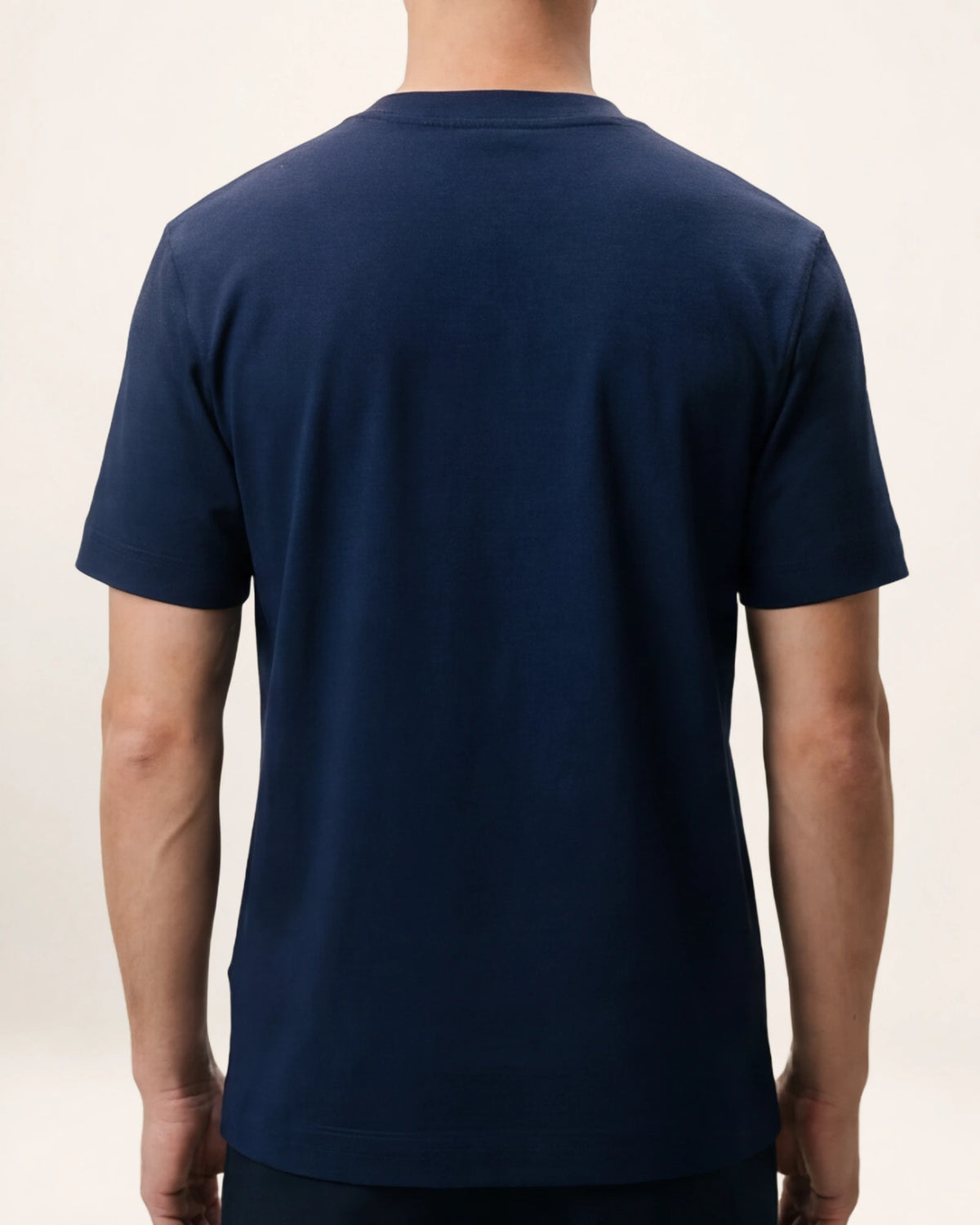 The Foundation Tee — navy T-shirt, back view on a model